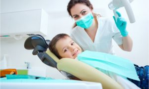 The dentist checks the kid's oral health.